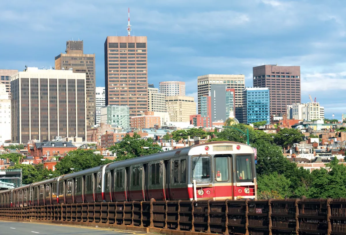Urban street scene with rail transit vehicle and downtown buildings.