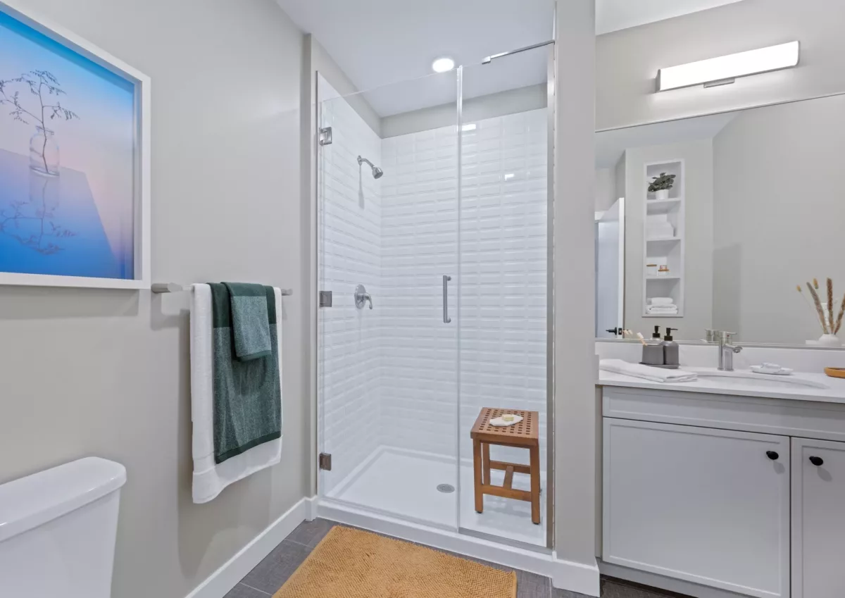 Bathroom with glass shower enclosure, white vanity, and modern fixtures.
