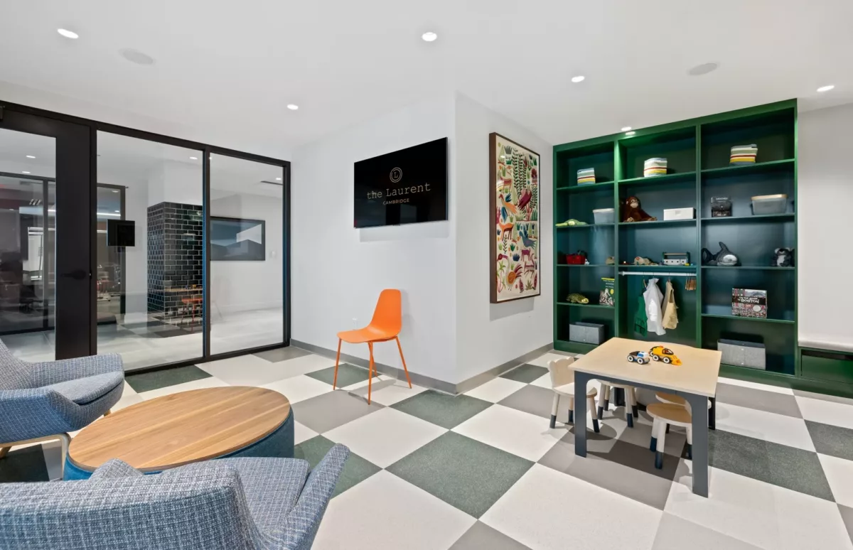 Game and activity room with seating, tables, and patterned flooring.
