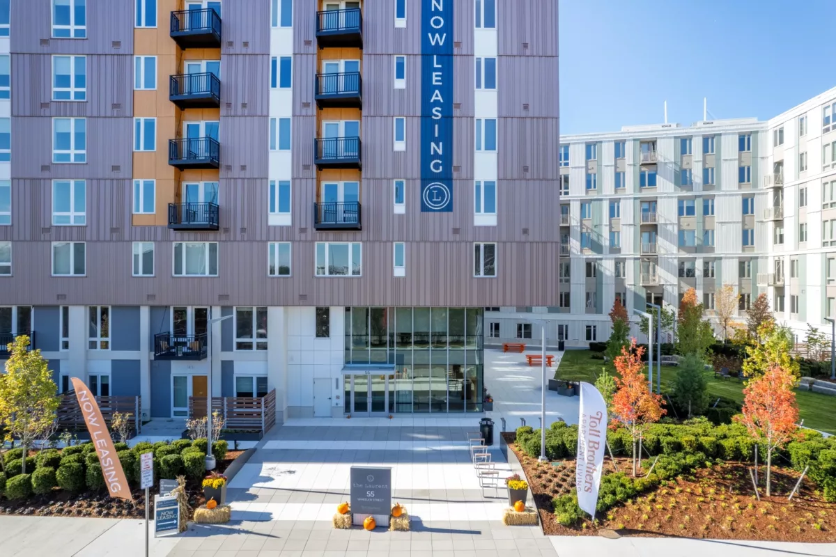 Contemporary multifamily exterior with balconies, ground‑level amenities, and landscaped outdoor seating area.