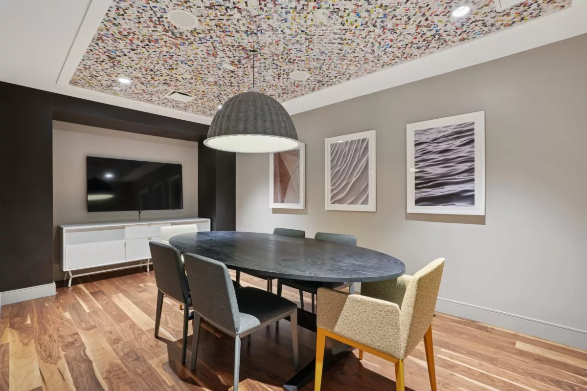 Private dining room with table, chairs, artwork, and wood ceiling details.