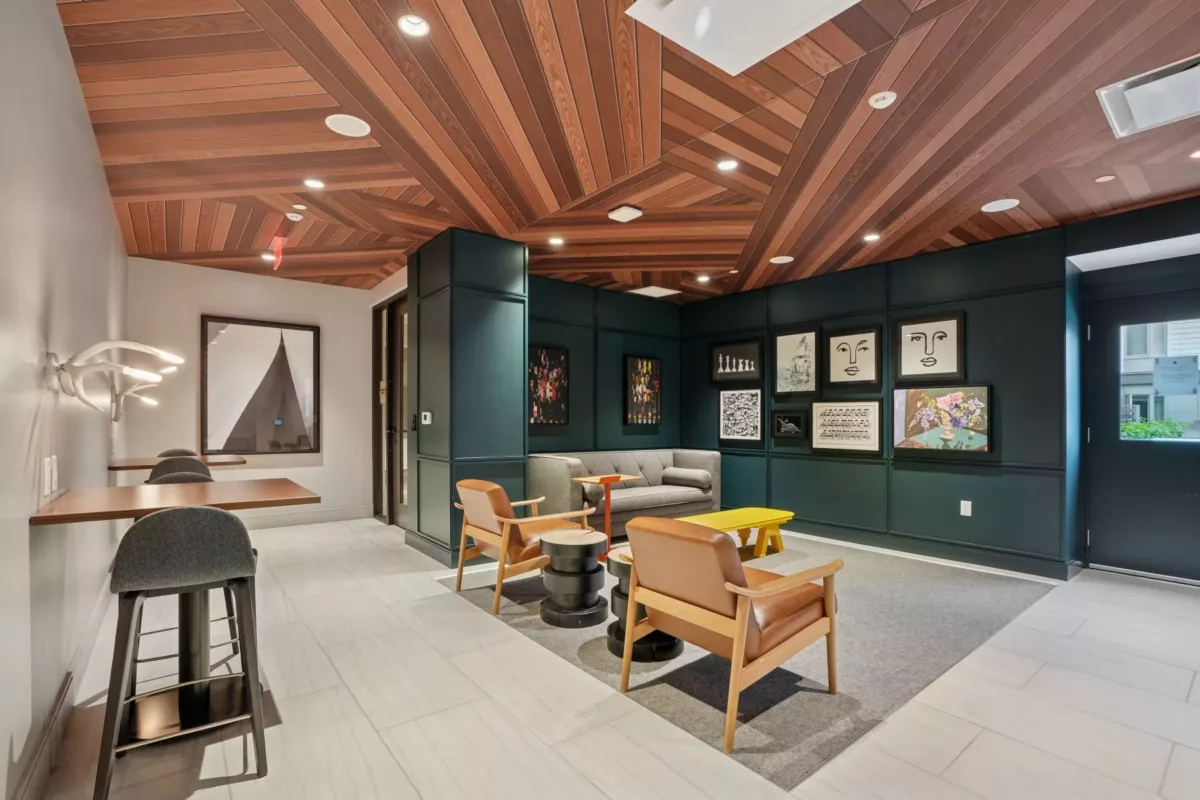 Resident lounge with sofas, accent chairs, and warm wood ceiling design.