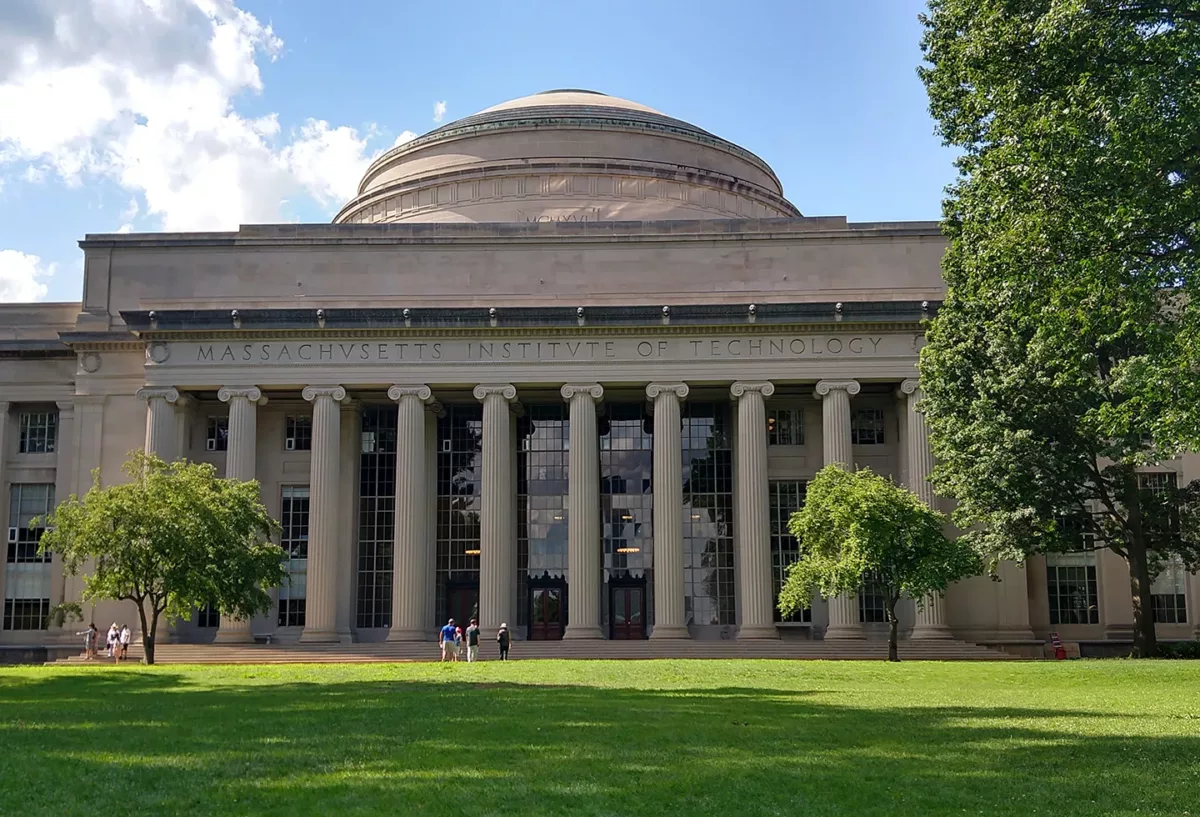 Classical domed building with columns set on a landscaped lawn.