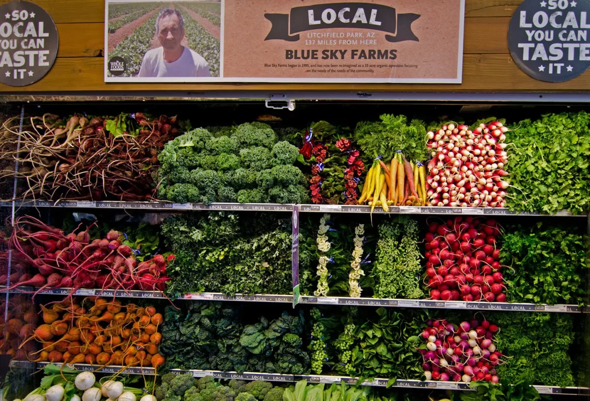 Market display of fresh fruits and vegetables arranged in crates.